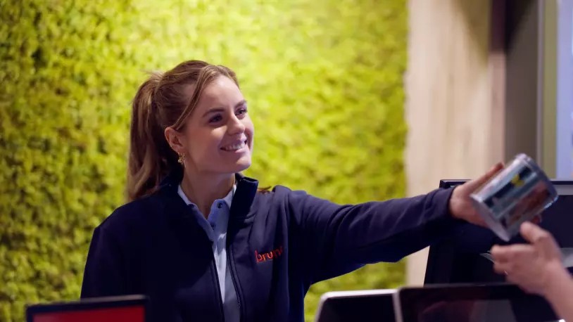 Bruna-medewerker helpt een klant bij de kassa